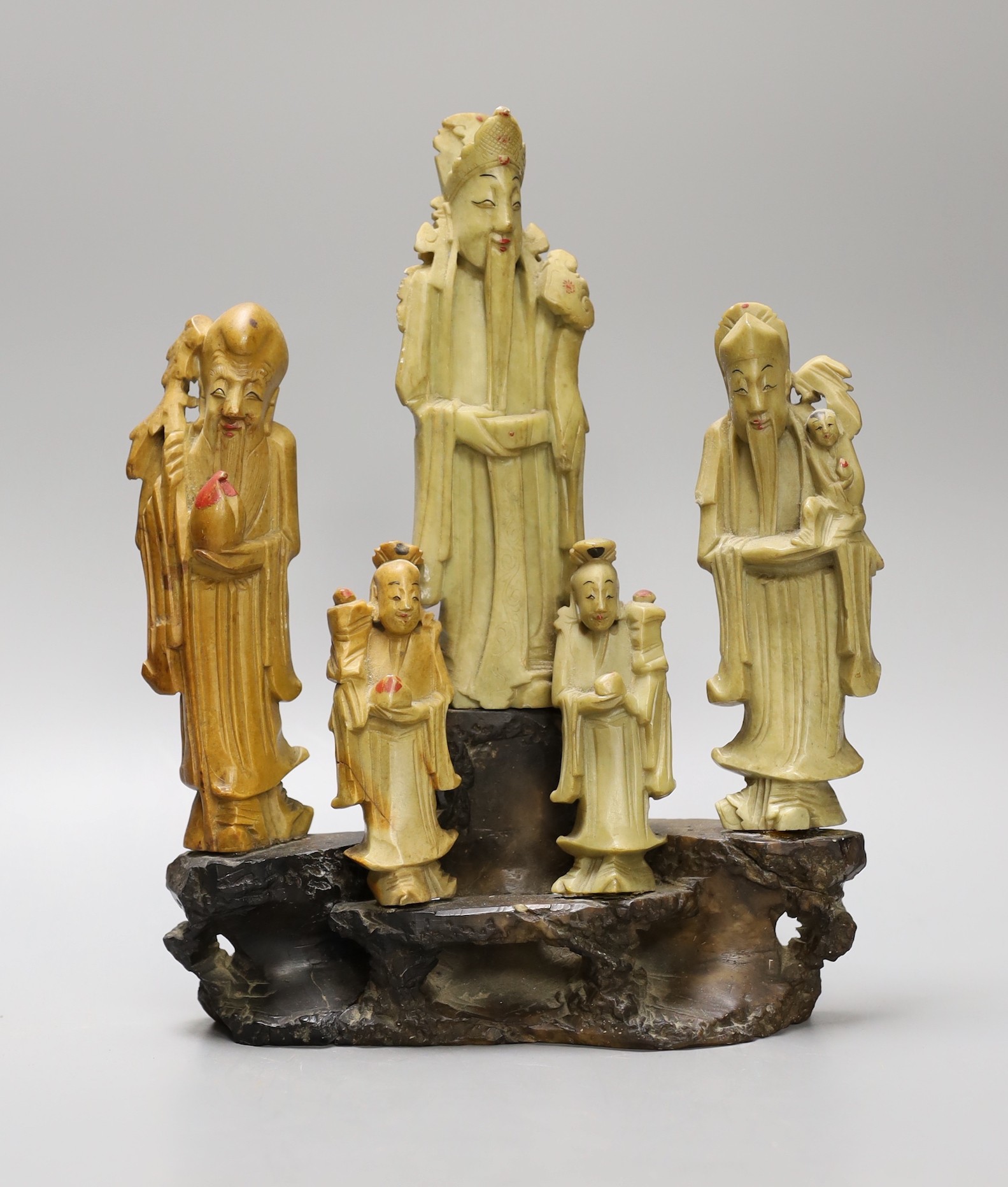 A Chinese soapstone five immortals group on graduated base, 28cm tall